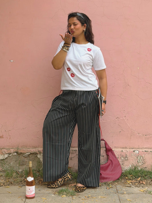 White graphic baby tee with red kiss embroidery details styled for outdoors