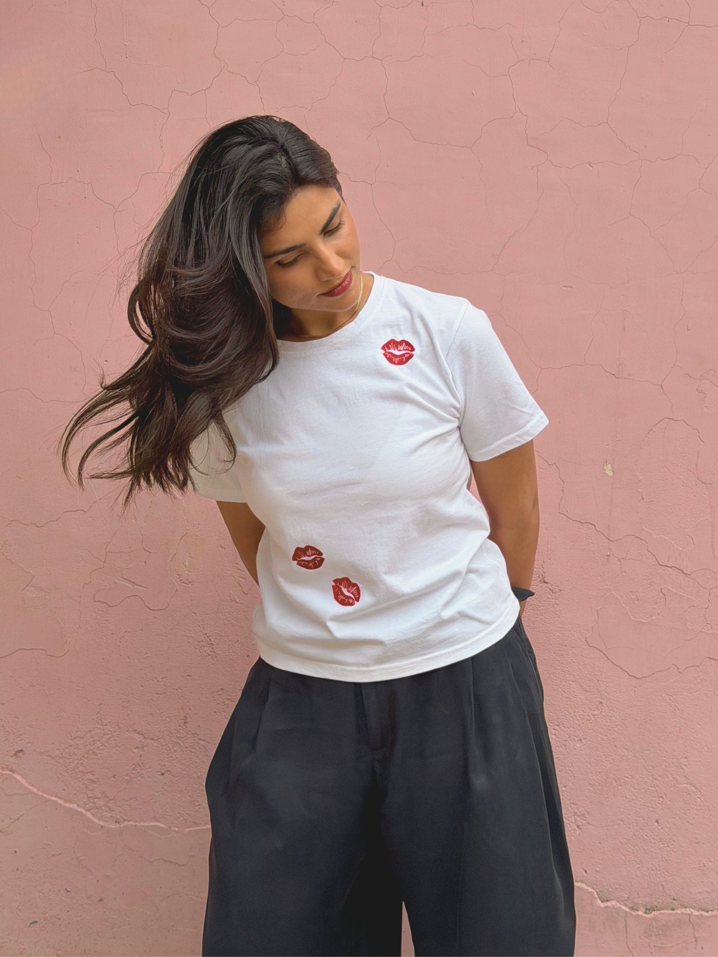 Minimal white baby tee with playful embroidered lip details as an elevated basic