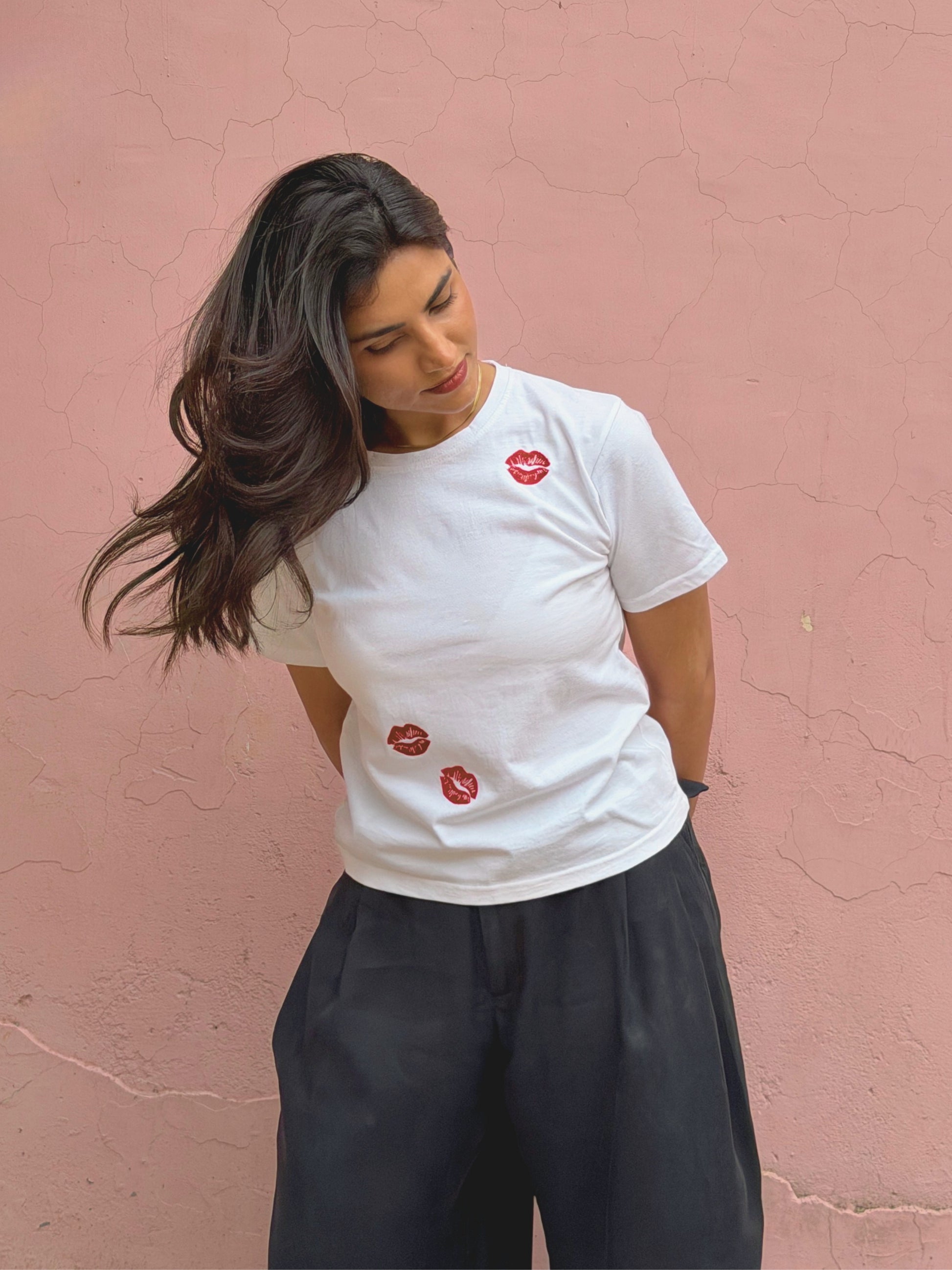 Minimal white baby tee with playful embroidered lip details as an elevated basic