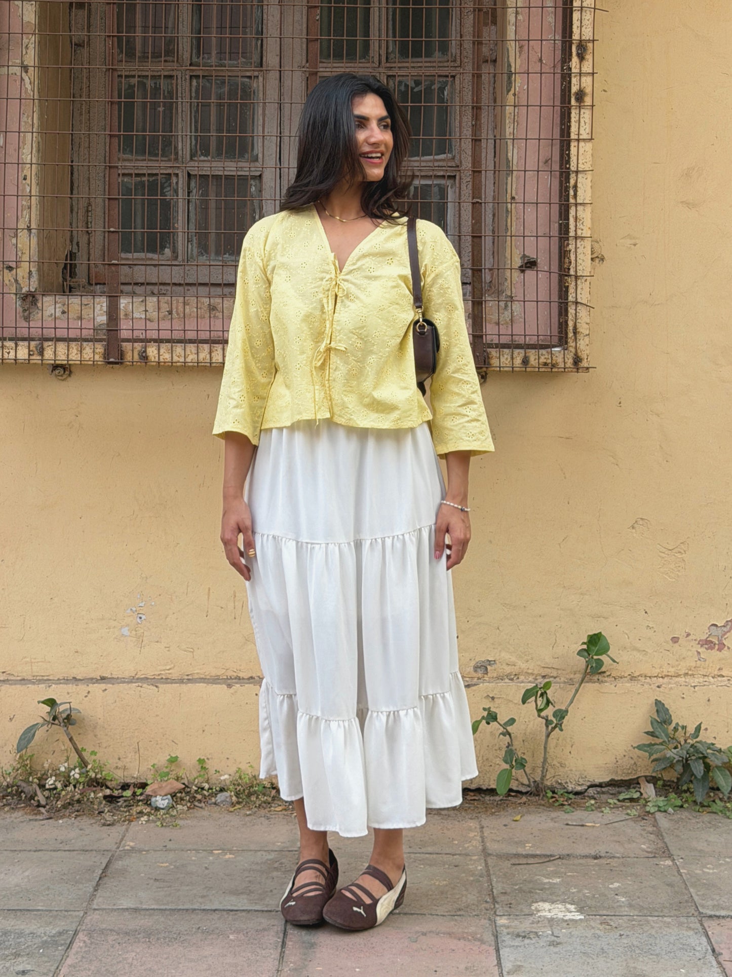 Model wearing yellow Ikami Copenhagen top with white skirt outdoors