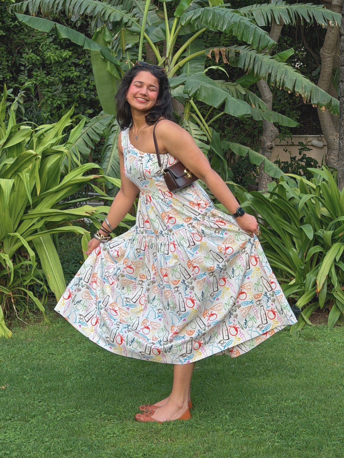 model in ikami amalfi dress posing outdoors with greenery in the background