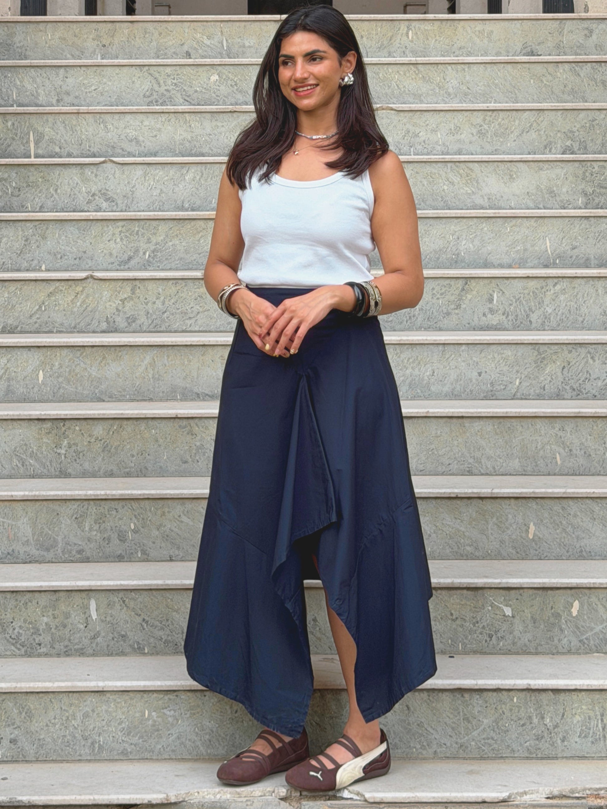 model wearing navy blue ikami berlin statement skirt on outdoor steps