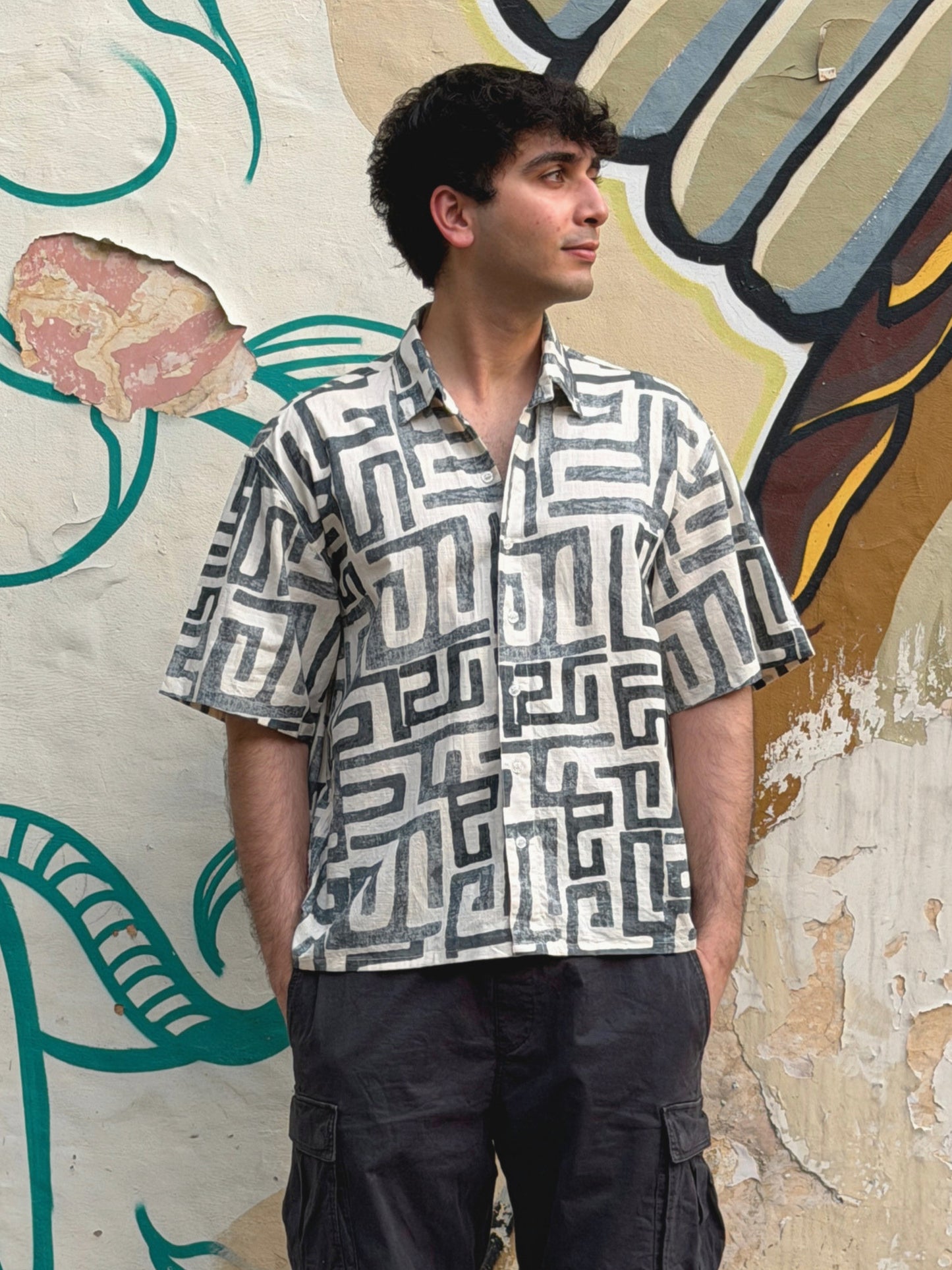 Man wearing the abstract ikami madrid shirt standing against a colorful wall.