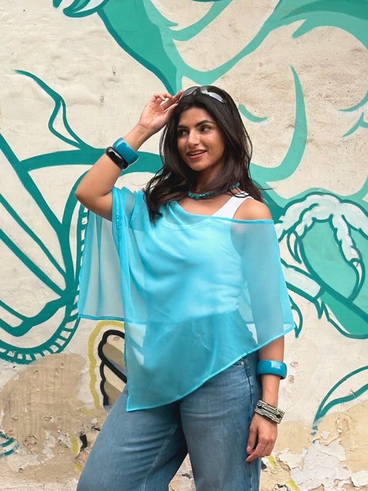model wearing blue sheer ikami porto poncho outdoors